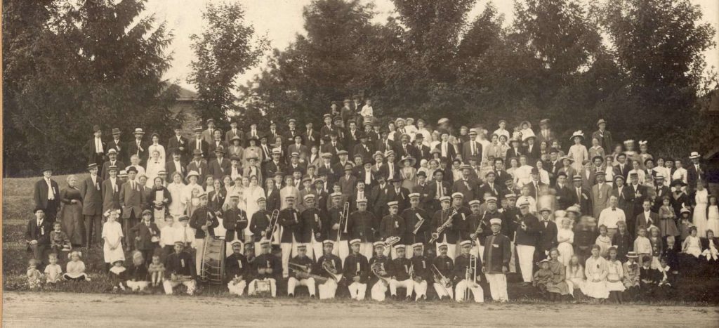 Group photograph of members of the Waterloo Musical Society band and others posing possibly in Waterloo Park, ca. 1900